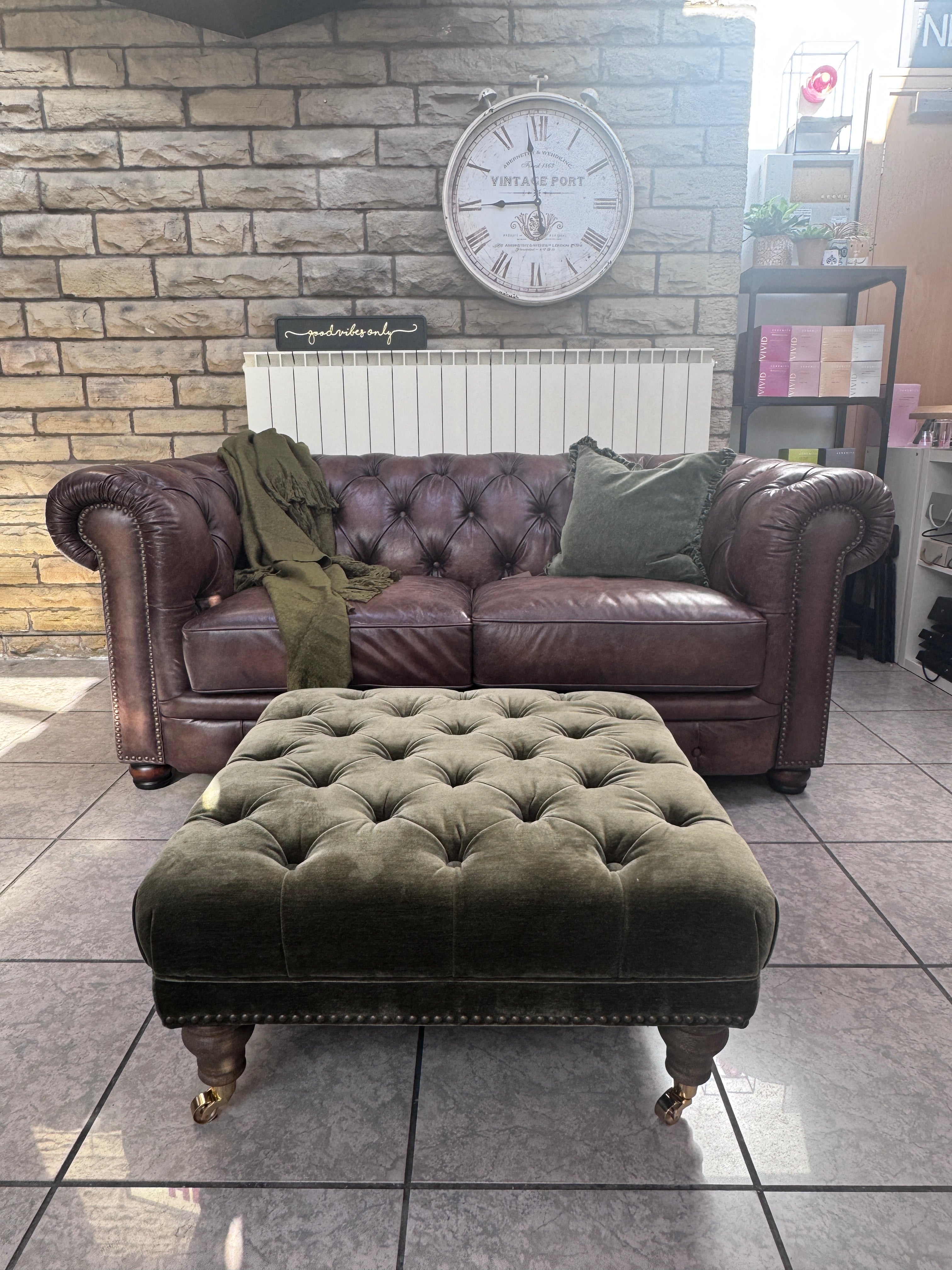 Shackleton square button top footstool with castors in Pine green velvet