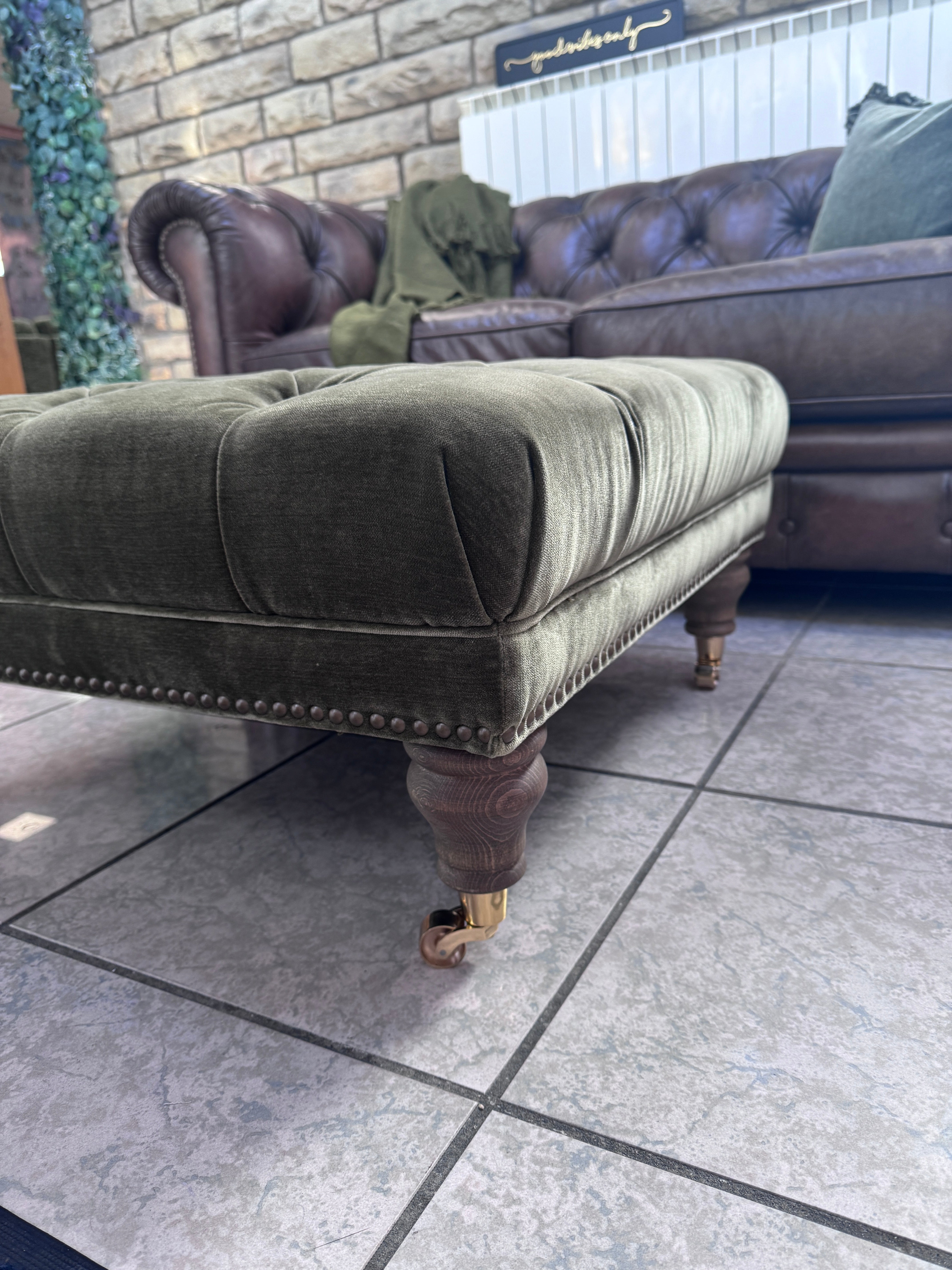 Shackleton square button top footstool with castors in Pine green velvet