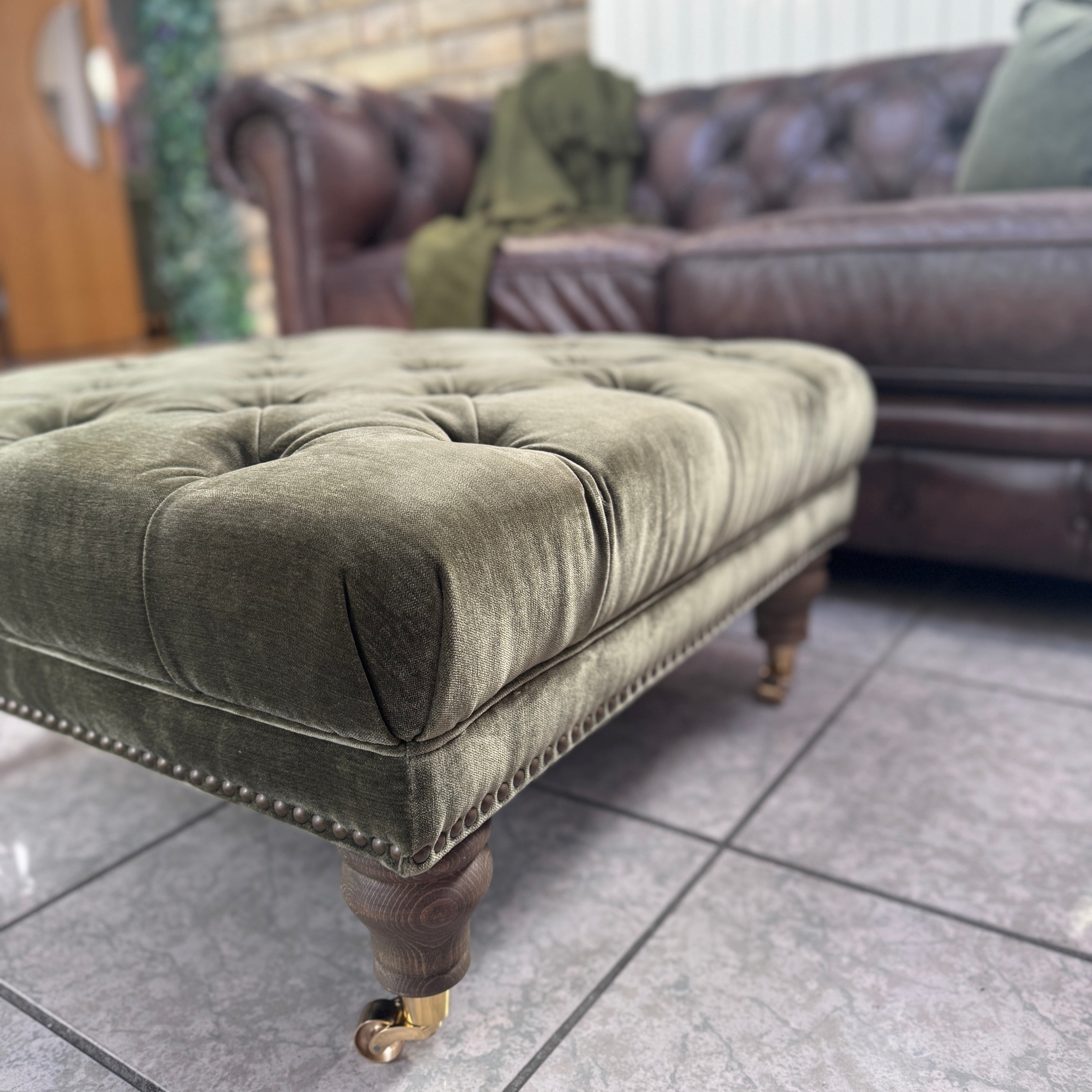 Shackleton square button top footstool with castors in Pine green velvet